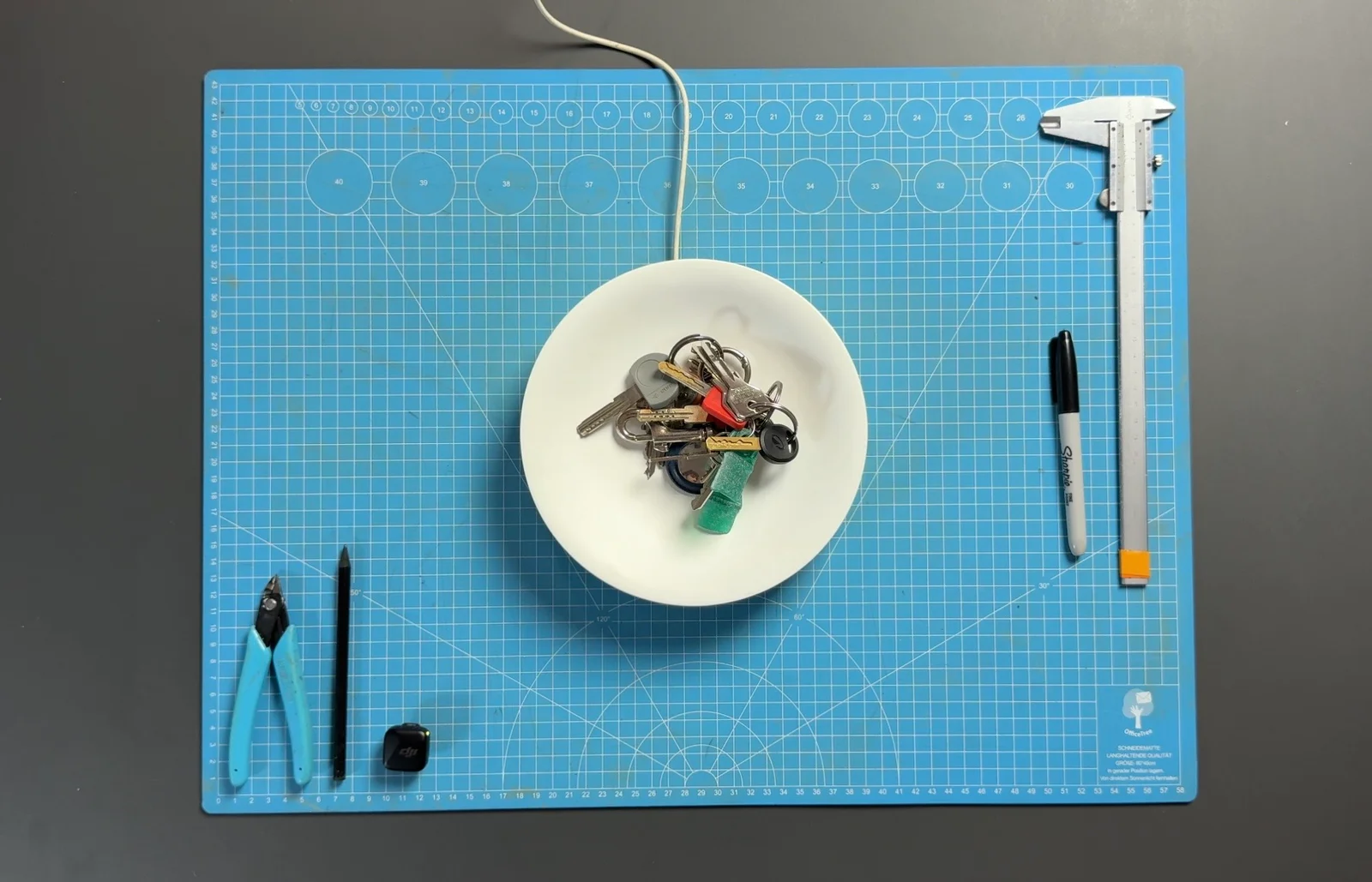 Il prototipo di Dory con le chiavi sul banco di lavoro, tra un calibro, un pennarello e gli strumenti di progettazione